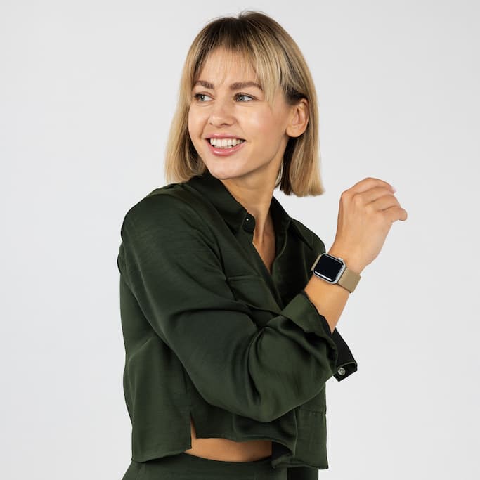 Smiling person in a dark green shirt, wearing a smartwatch.
